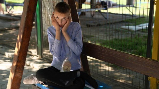 Child on bench holding face in hands