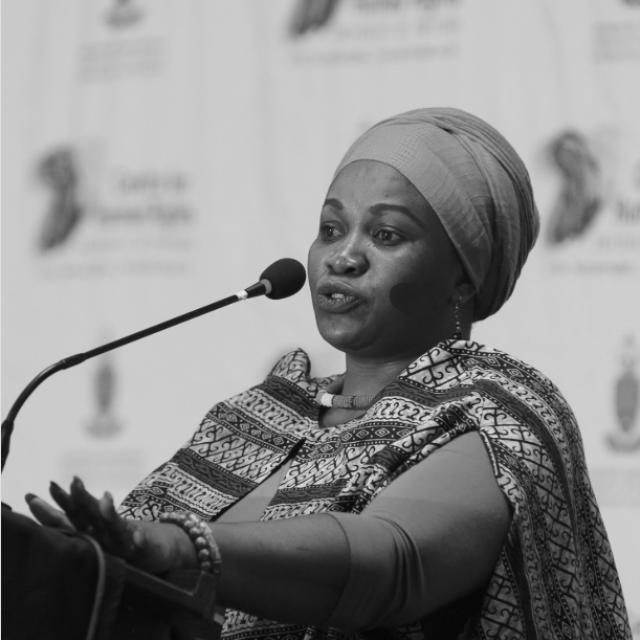 Woman stands speaking at a podium