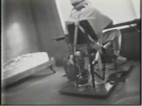 -Child restrained at waist, arms, chest, groin and feet in isolation room