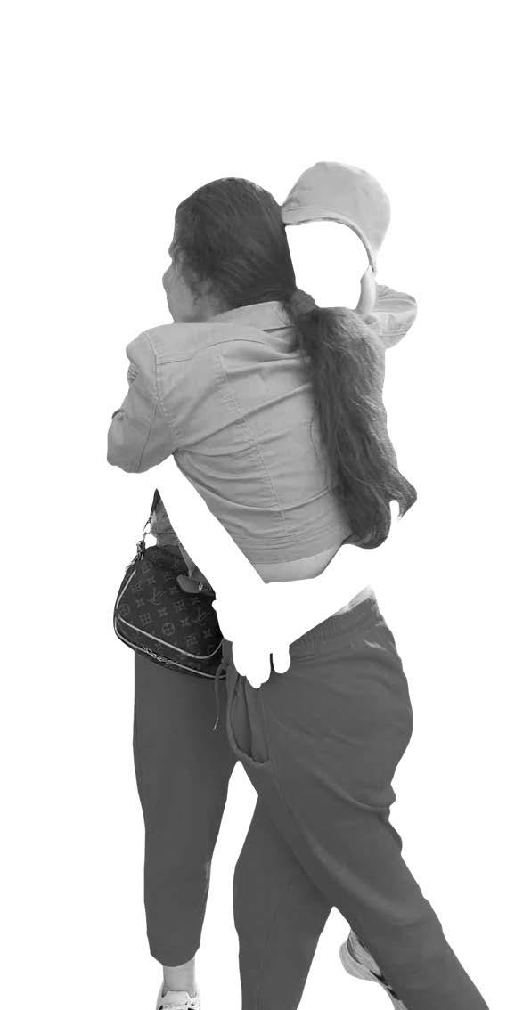 black and white image of a woman and teen girl hugging one another. The womans face and arms are cut out of the photo so only her clothes are visible