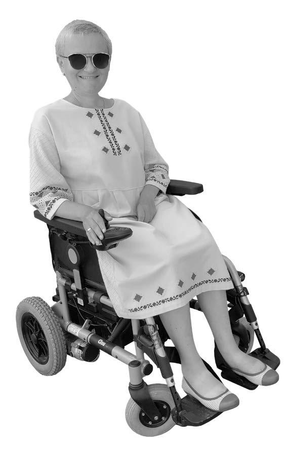 black and white image of a woman smiling, in a motorized wheelchair