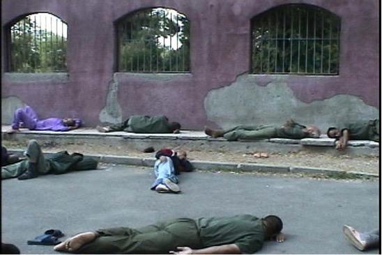 several people laying down outside on asphalt and concrete
