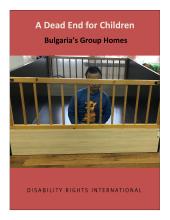 a child sitting in a wooden cage with his face covered by bars